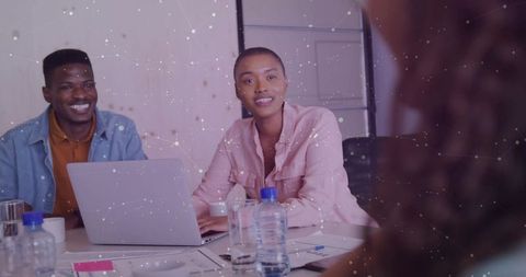 Diverse Team Meeting with Laptops and Papers in Office Setting