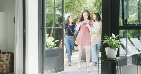 Female Friends Arriving at Sunlit Holiday Home for Vacation