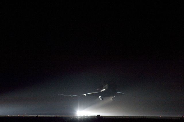 Space Shuttle Endeavour lands at Kennedy Space Center runway at night with xenon lights guiding the way. Useful for illustrating significant moments in space exploration history, showcasing the achievements of NASA, and highlighting night operations at space facilities. Ideal for articles or educational materials on space shuttle missions and NASA’s Space Shuttle Program.