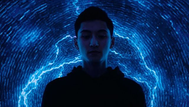 Moody futuristic portrait young man hoodie neon blue led rings glowing electric light halo