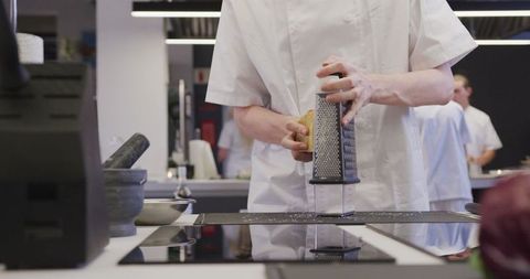 Chef Grating Cheese in Sophisticated Restaurant Kitchen