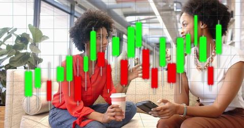 Two women discussing stock trading over coffee with candlestick chart overlay in coworking