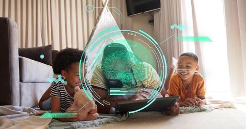 Dad and children enjoying tablet together on living room rug with cozy teepee