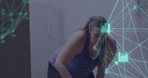 Sweaty woman pausing during workout with digital fitness network overlay on industrial concrete wall