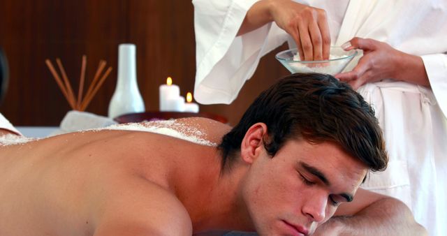 Handsome man getting a salt scrub treatment at the spa - Download Free Stock Photos Pikwizard.com