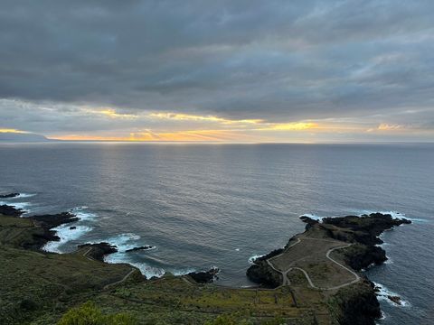 Scenic coastal beach landscape with sun rays and cloudy sky at sunset