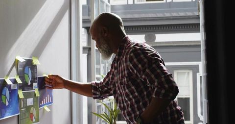 Senior Professional Analyzing Data Charts in Modern Office