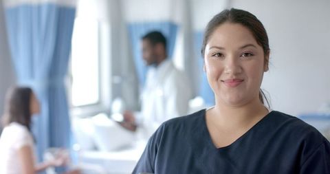 Smiling Female Doctor Using Digital Tablet in Hospital Ward