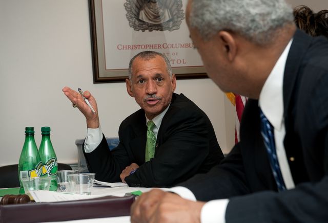 The image depicts NASA Administrator Charles Bolden engaging in a conversation during a Congressional Black Caucus meeting on January 13, 2010, in Washington, DC. This image can be used to illustrate governmental meetings, political discussions, leadership, and communication within legislative bodies, especially focusing on contributions by African American leaders.
