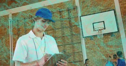 Teenage boy coaching basketball team in gymnasium