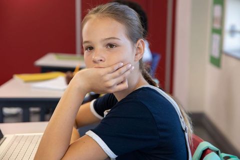 Teenage Girl Engaged in Class with Laptop and Notebook