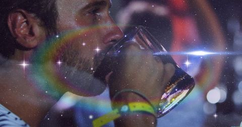 Man Enjoying Beer at Vibrant Pub with Radiant Lens Flares