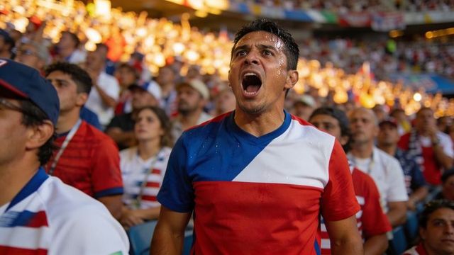 Shouting soccer fan wearing red white blue jersey sweating intense stadium emotion