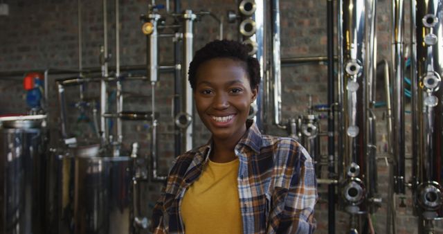 Portrait of happy african american woman working at gin distillery smiling to camera. work at an independent craft gin distillery business.
