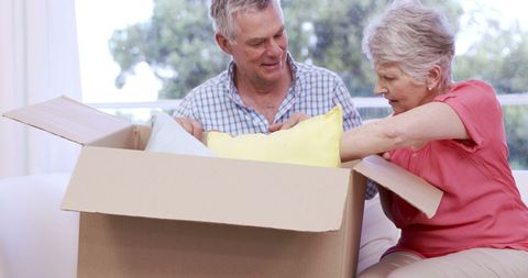 Senior Couple Joyfully Unpacking Box in Bright Living Room - Download Free Stock Images Pikwizard.com