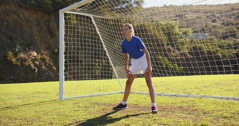Focused Girl Goalkeeper Standing in Soccer Field Ready for Action