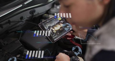 Female technician using tablet for augmented reality engine diagnostics on car battery