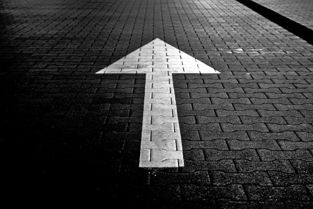 white arrow points upward on dark cobblestone street at night - Download Free Stock Photos Pikwizard.com