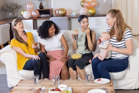Diverse Women Enjoying Time in Living Room with Baby and Snacks