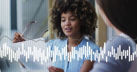 Diverse Businesswomen Analyzing Data Charts in Modern Office