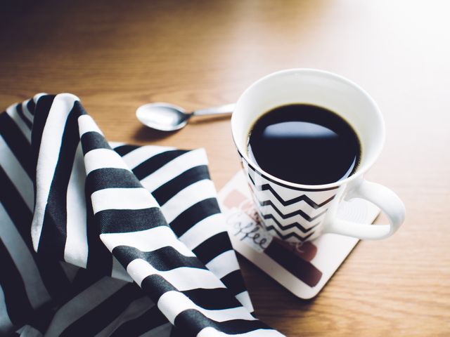 Cup of Coffee on Table with Black and White Striped Cloth - Download Free Stock Photos Pikwizard.com