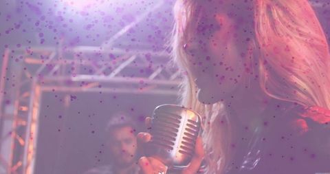 Female vocalist singing on stage with vintage microphone