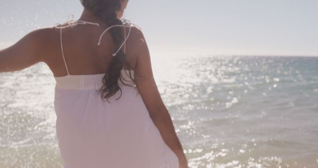 Woman in White Dress Enjoying Sunlit Beach - Download Free Stock Images Pikwizard.com