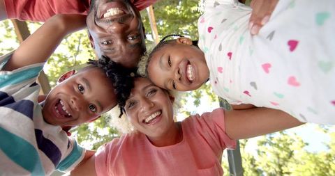 Joyful Diverse Family Huddling Outdoors Laughing Together