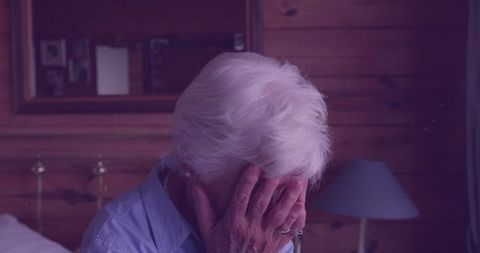 Elderly Woman Grieving in Dimly Lit Room