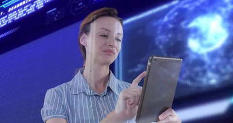 Mid-adult woman using tablet in futuristic control room with holographic globe and data panels