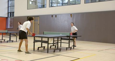 Multiracial Team Enjoying Table Tennis in Modern Gym