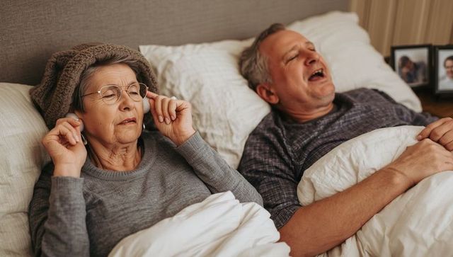 Senior woman uses earplugs for sleep despite husband's snoring