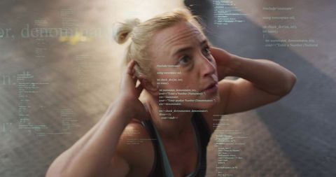 Woman adjusting earbuds mid-workout with code overlay linking fitness and tech