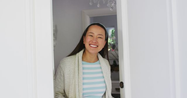 Happy asian woman opening front door, smiling and greeting visitor to home. happy family, domestic life at home.