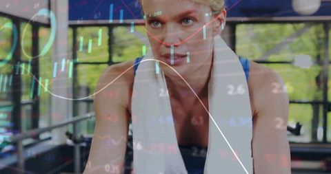 Pedaling woman on stationary bike with data overlay for fitness performance analytics