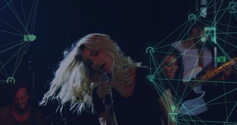 Blonde lead singer performing live with band, teal digital overlay, microphone motion