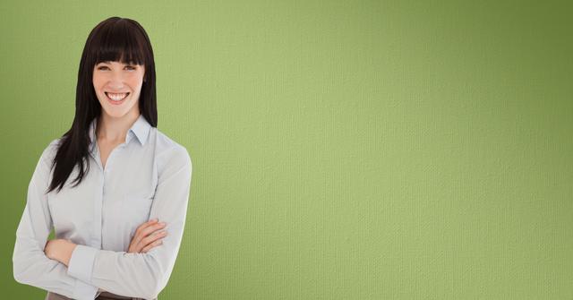 Smiling woman with black hair stands confidently with arms crossed against a bright green background. Ideal for business or professional related content, corporate presentations, and marketing materials showcasing confidence and positivity. Useful for websites, social media promotions, and advertisements emphasizing a positive and professional demeanor.