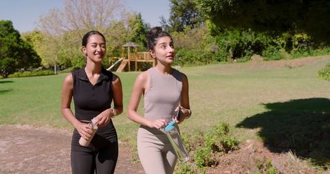 Female Friends Enjoying Refreshing Walk in Sunny Park