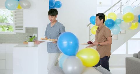 Setting up home party with colorful balloons and snacks