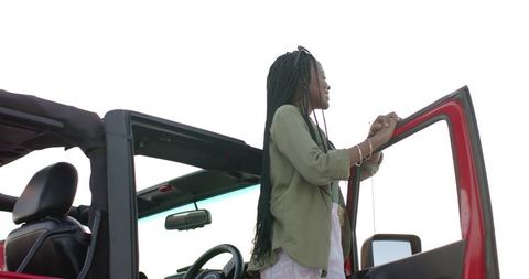 Young woman enjoys road trip with red convertible