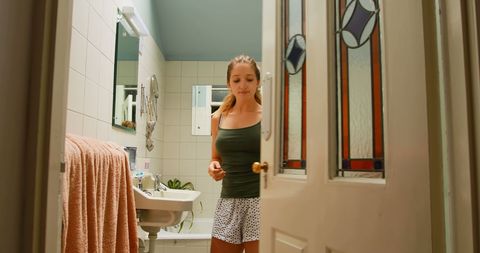 Woman Getting Ready in Cozy Home Bathroom with Vintage Details