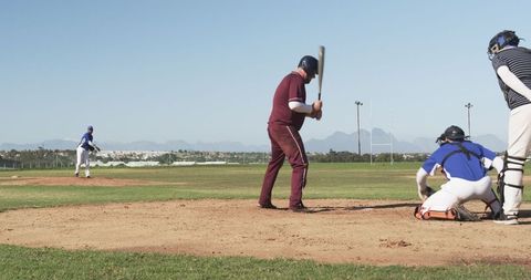 Baseball player swinging bat at home plate in outdoor stadium