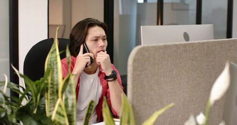Asian Businessman Communicating with Smartphone in Modern Office