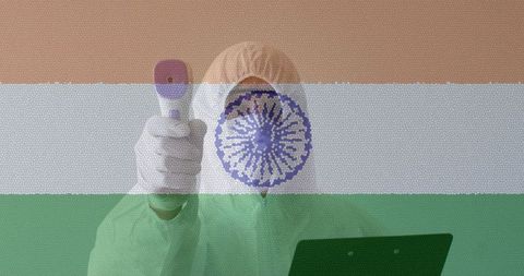 Healthcare worker checking temperature of patient overlaid indian flag