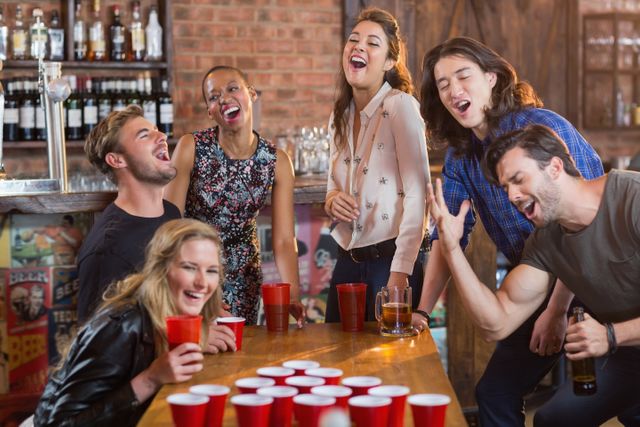 Friends Celebrating with Beer Pong in Lively Bar - Download Free Stock Photos Pikwizard.com
