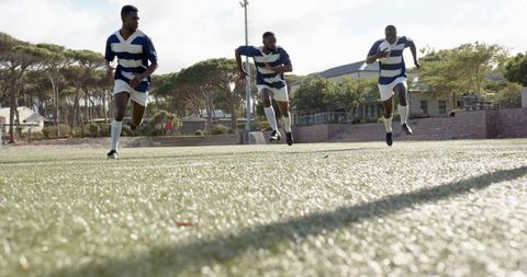 Young Athletes Sprinting on Turf Field in Rugby Uniforms