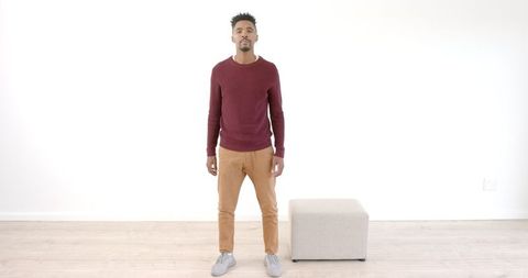 Confident Man in Minimalist Bright Room Fashionably Dressed in Casual Attire