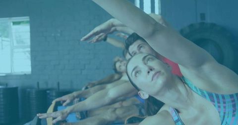 Group pilates class stretching on reformers in gym