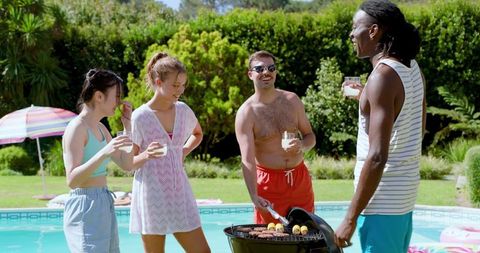 Diverse Friends Enjoying Barbecue by Poolside on Sunny Day