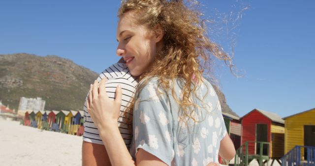 Couple Hugging on Sandy Beach with Colorful Beach Huts - Download Free Stock Images Pikwizard.com